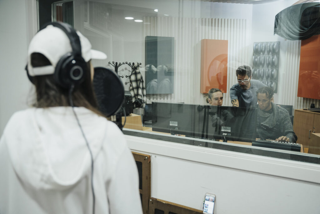 Estudiant d’EUMES gravant en un estudi de música electrònica amb auriculars d’estudi.