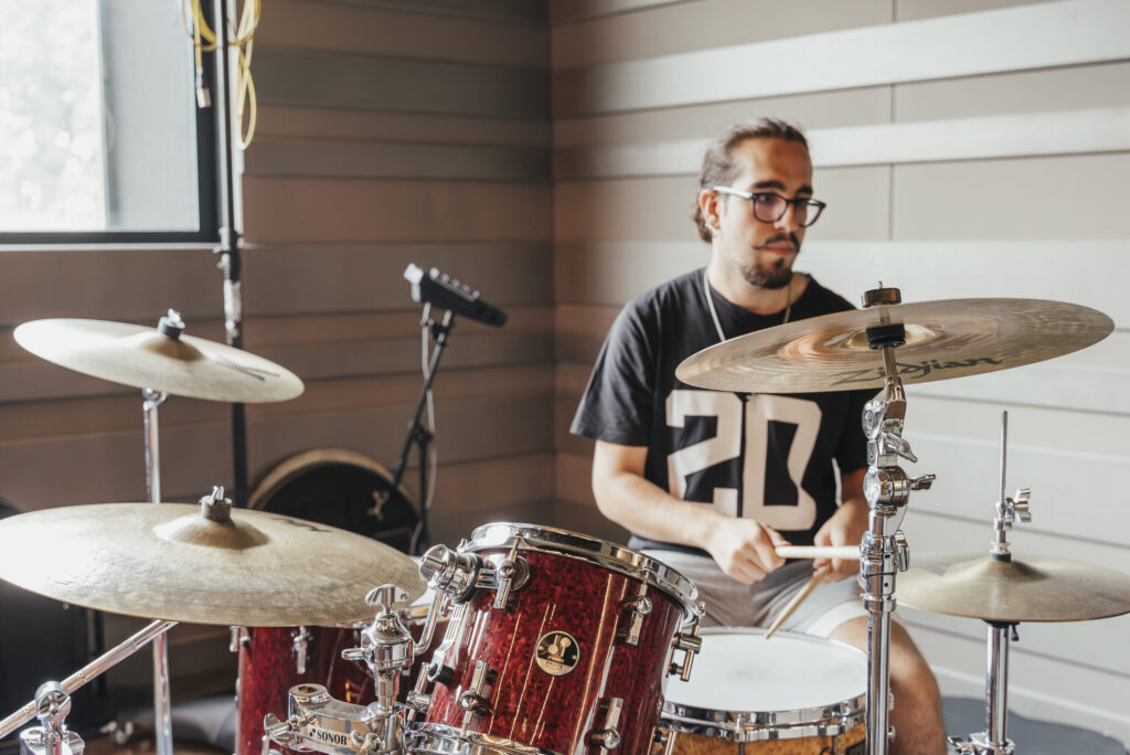 Estudiant de bateria en una aula d’assaig d'Eumes, centrant-se en la seva formació per entrar al negoci musical